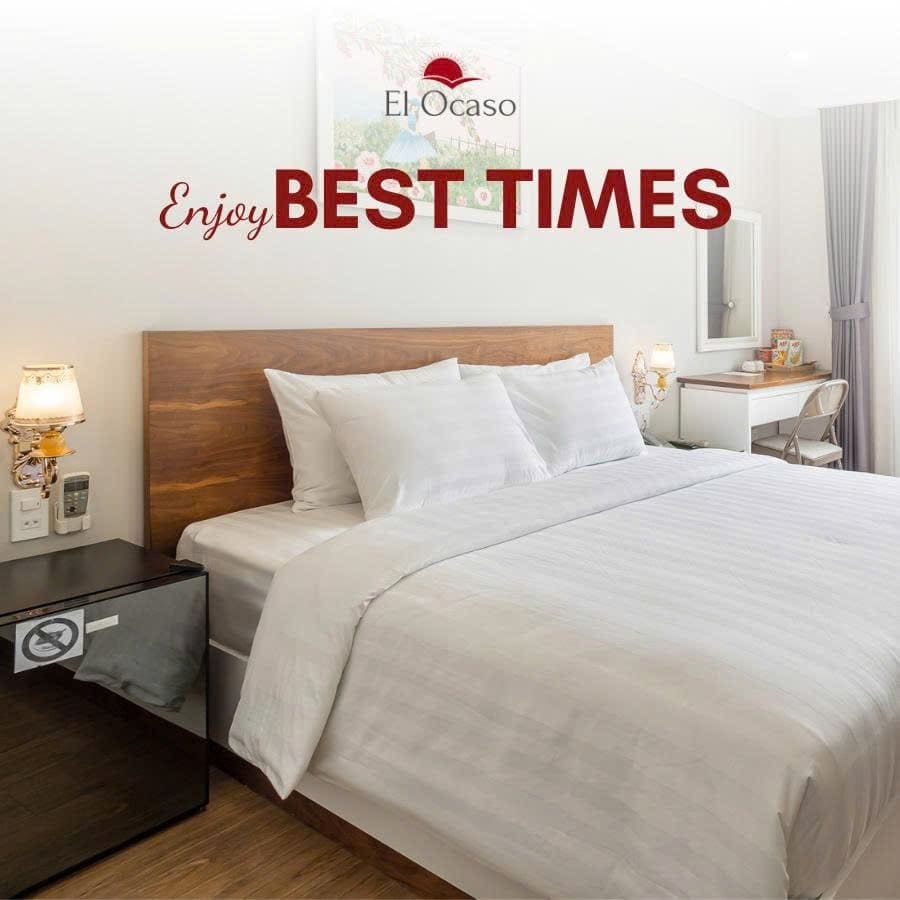 Cozy modern bedroom with wooden headboard at El Ocaso Hotel Saigon