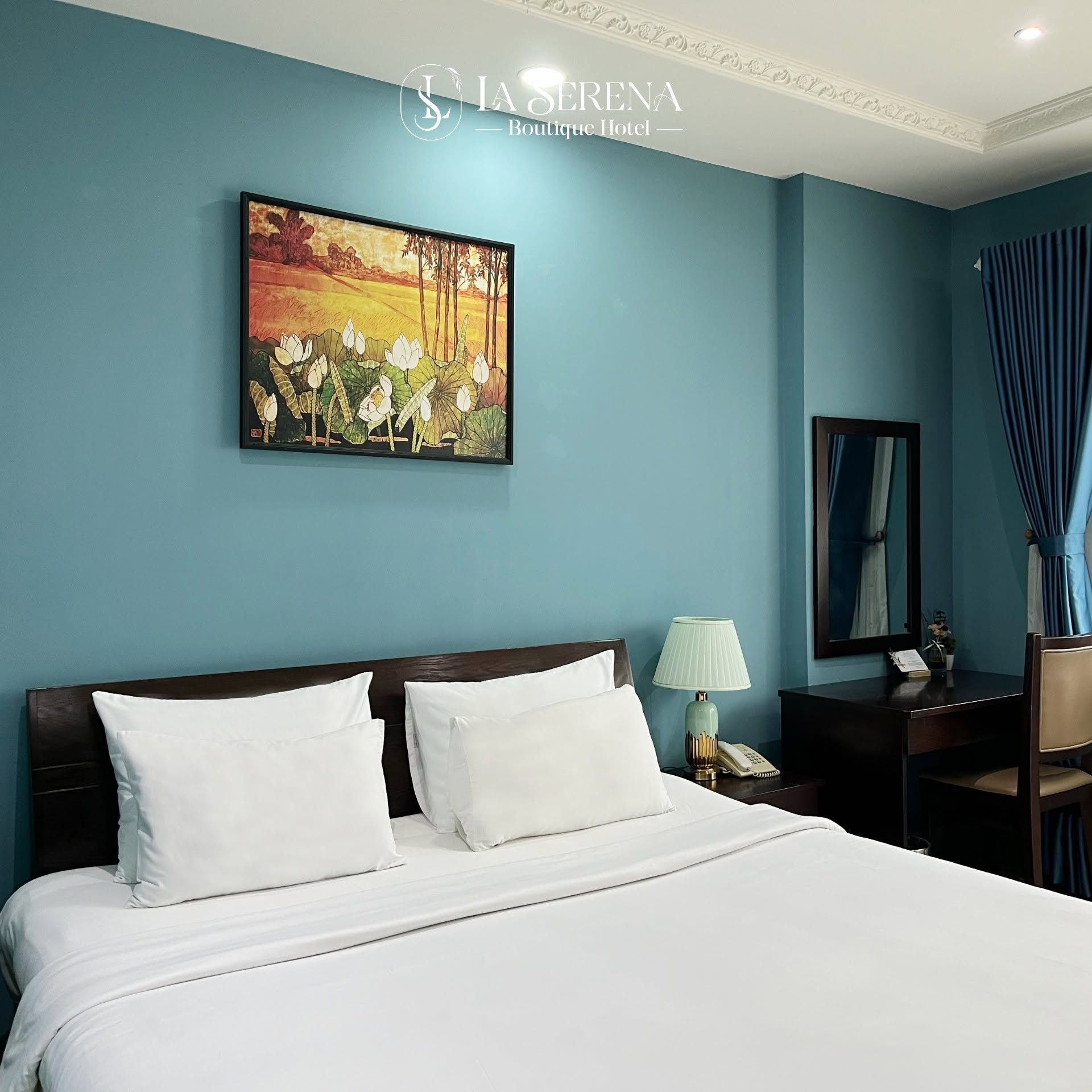 Phòng đôi sang trọng với tranh đầm sen trên nền tường xanh tại La Serena Boutique Hotel Quận 7