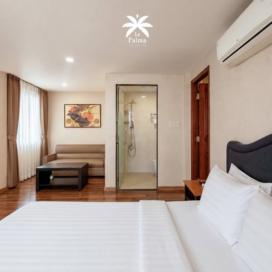 Phòng khách sạn tiện nghi tích hợp phòng tắm kính và sofa tại La Palma Garden Hotel Quận 7